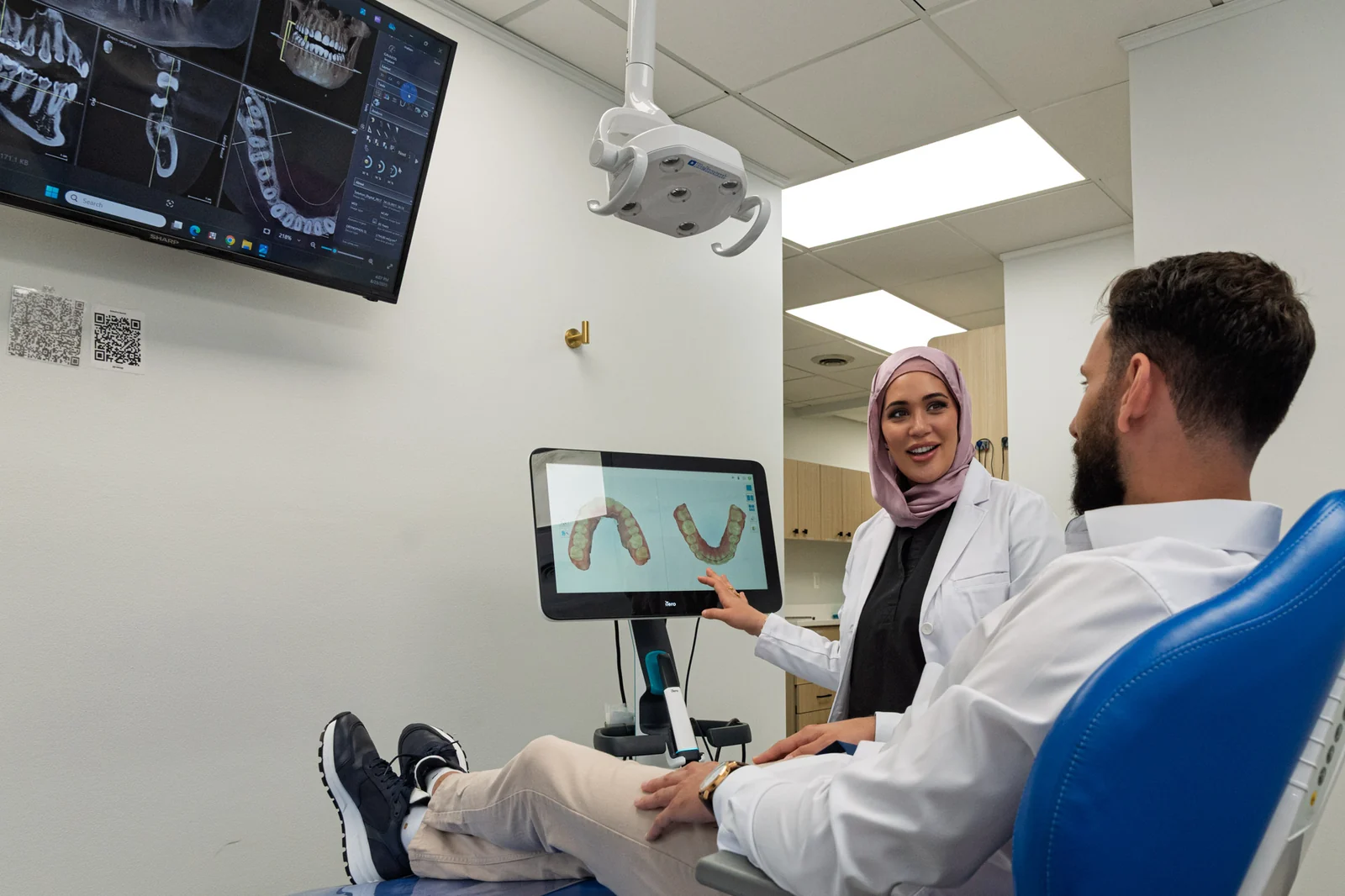 A SmilePro Dental clinician reviewing treatment options with a patient on a chairside screen