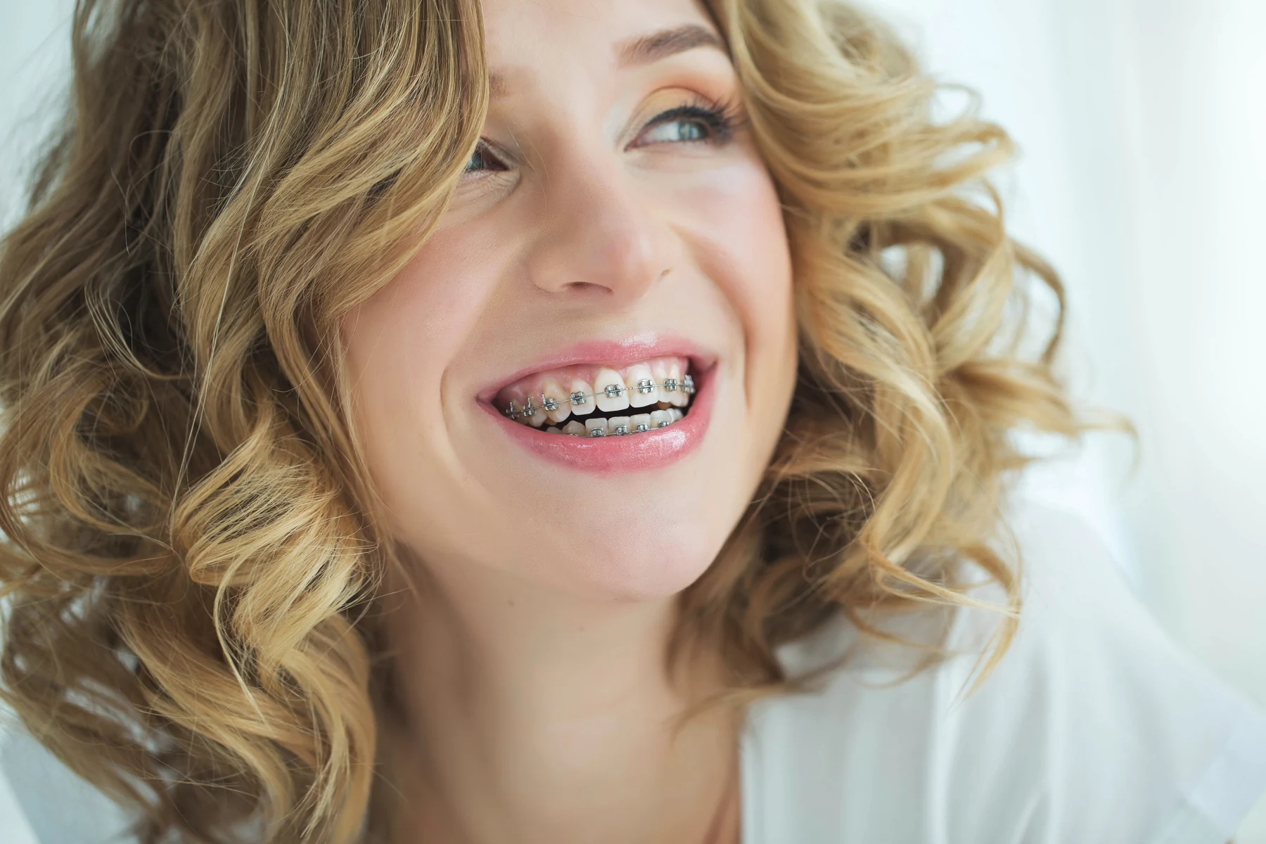 A patient smiling confidently with braces