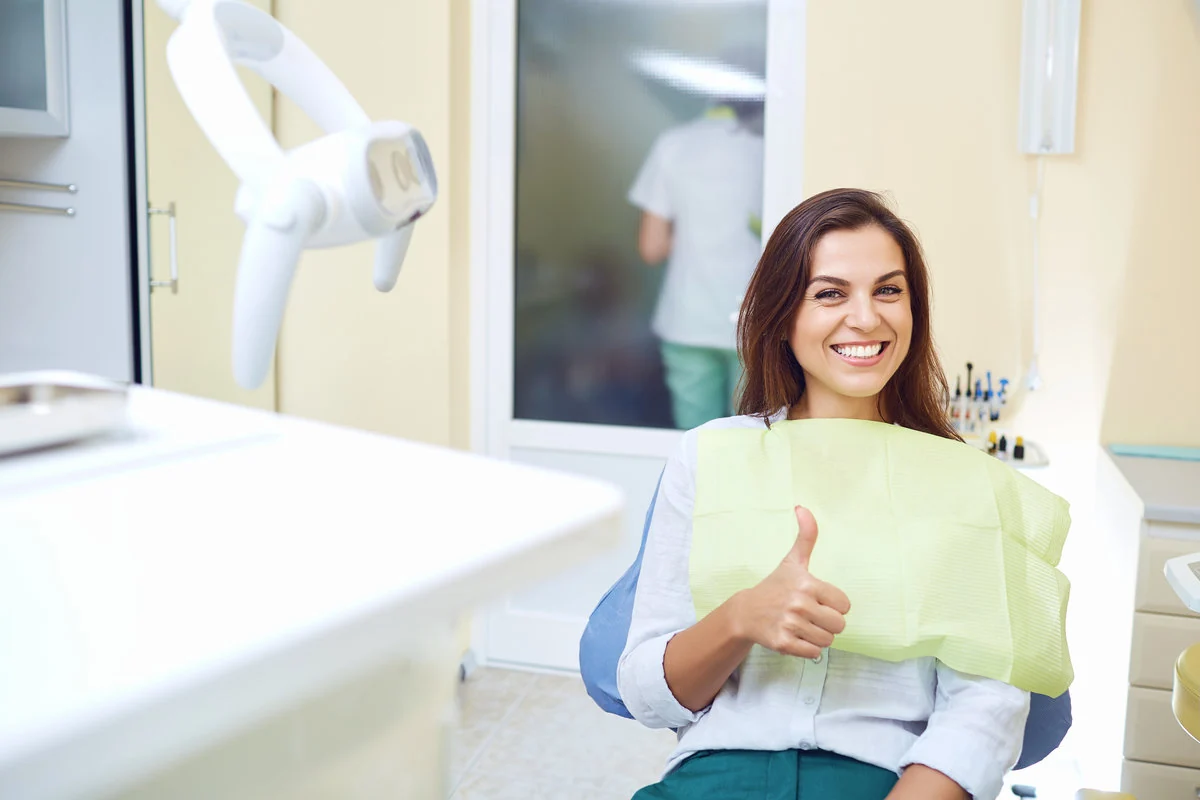 A happy patient giving a thumbs-up after dental treatment
