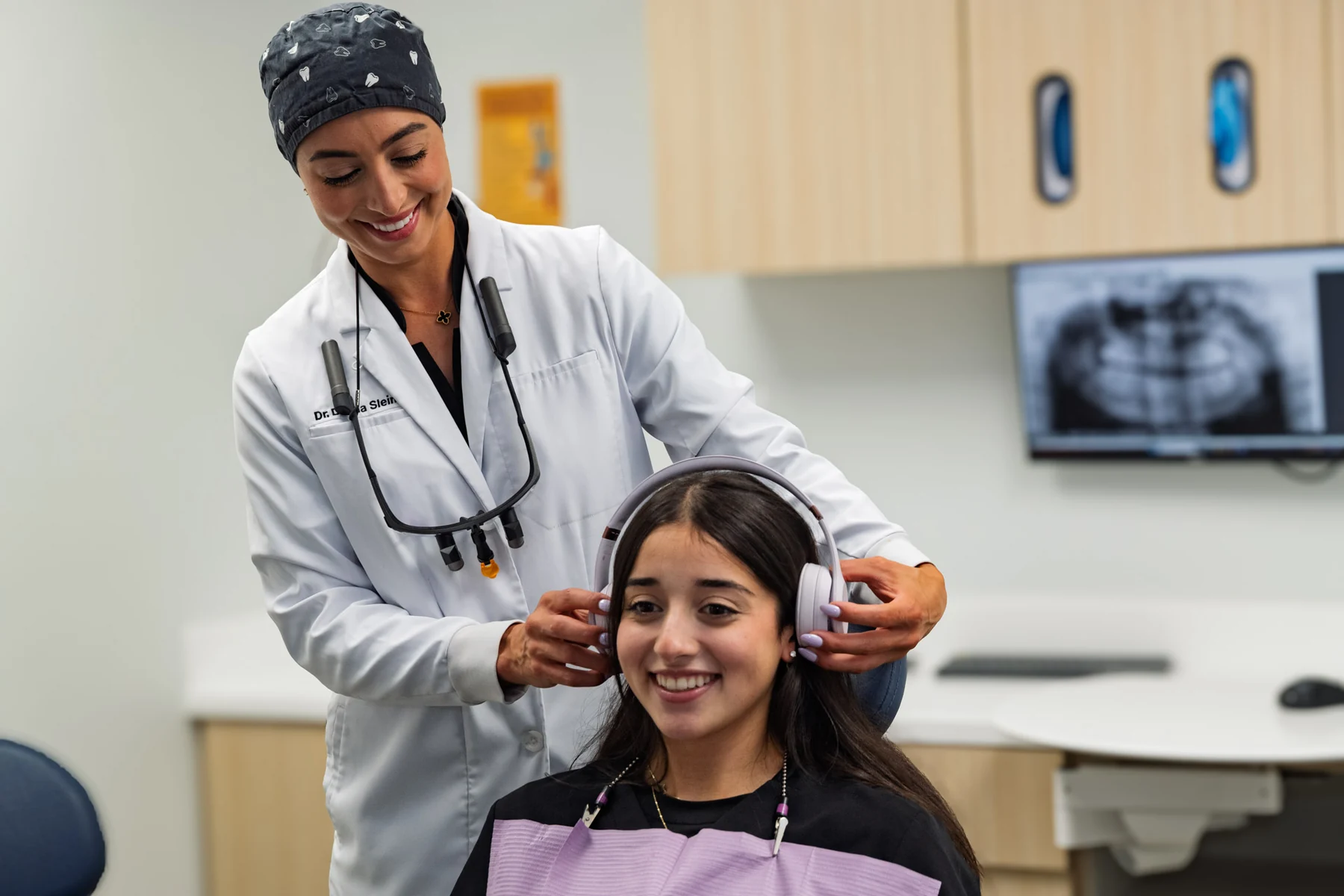 A SmilePro Dental clinician showing a young patient a treatment model