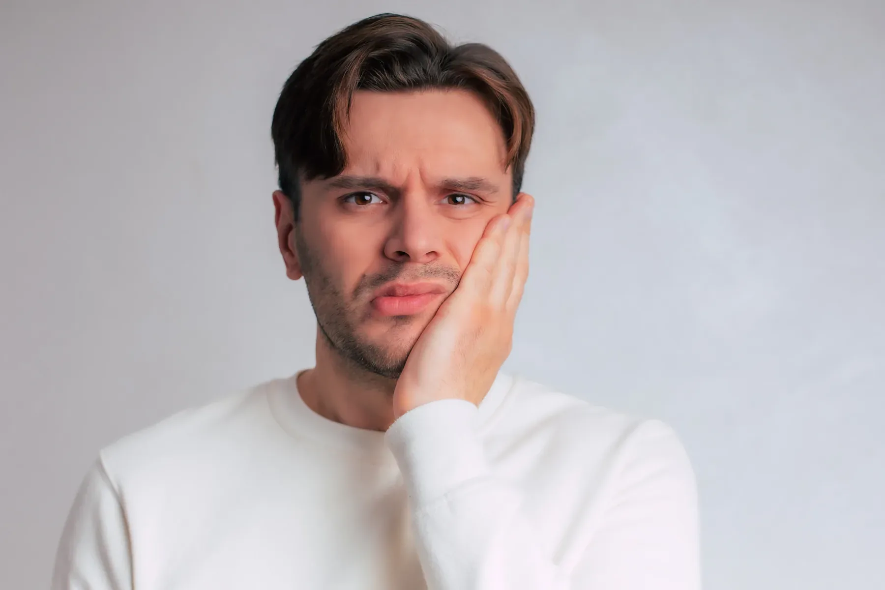 A man holding his cheek — Pain Diagnosis & Management at SmilePro Dental