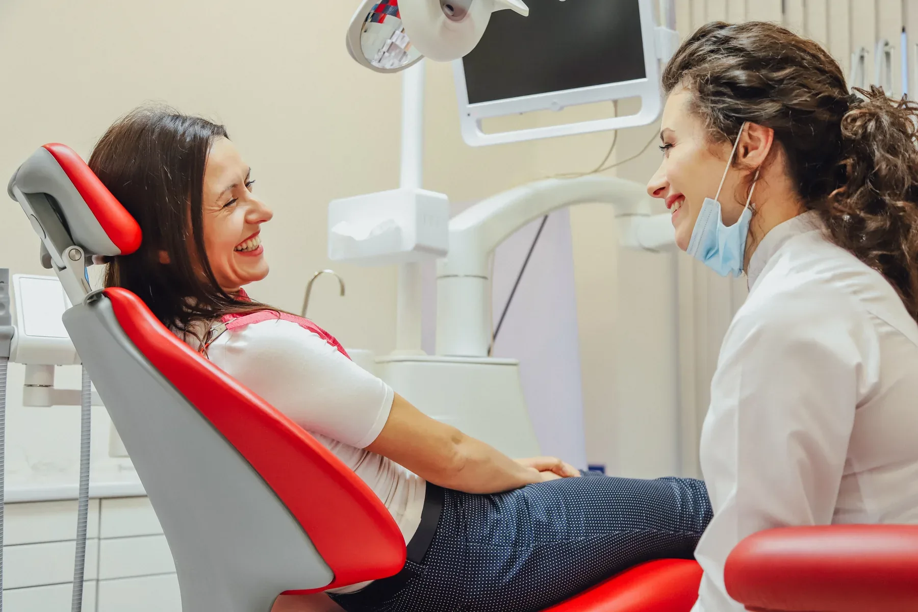 A patient chatting with her dentist in the dental chair