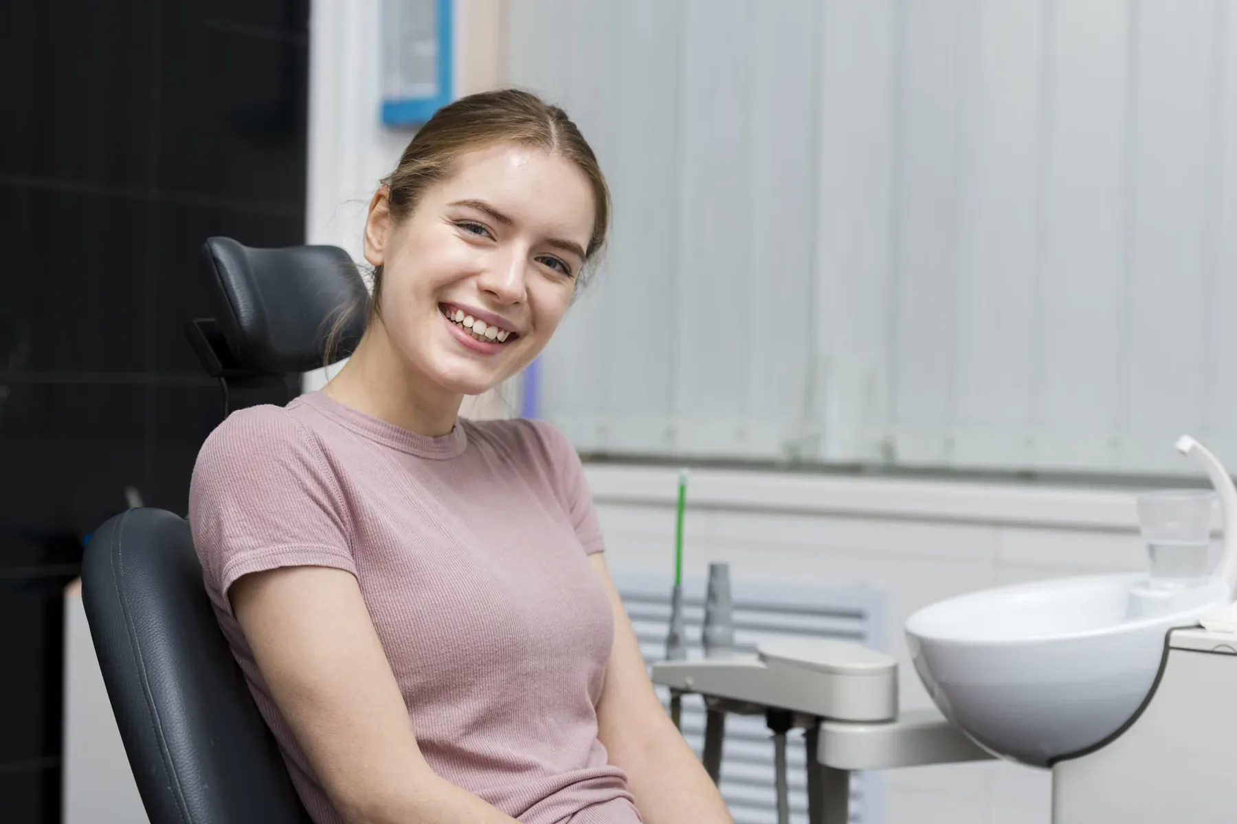 A smiling young woman seated in the dental chair — Laser Dentistry at SmilePro Dental